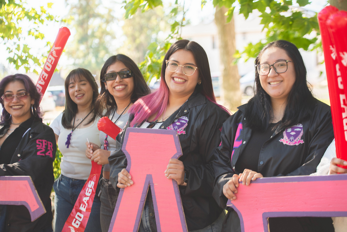 Five members of a sorority welcome students.