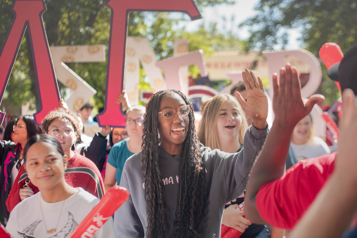 New EWU student trustee offers high-fives to new students.