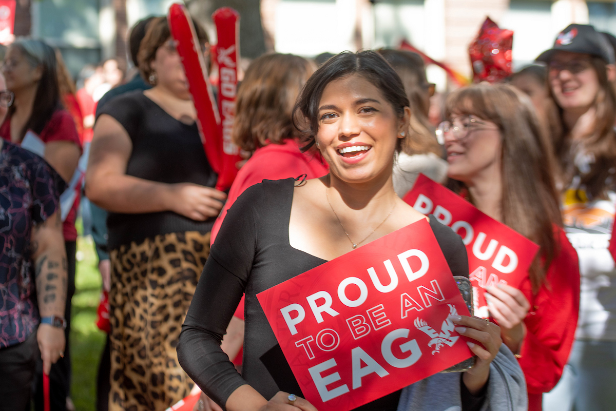 Campus member holding up a Proud to be an Eag sign.