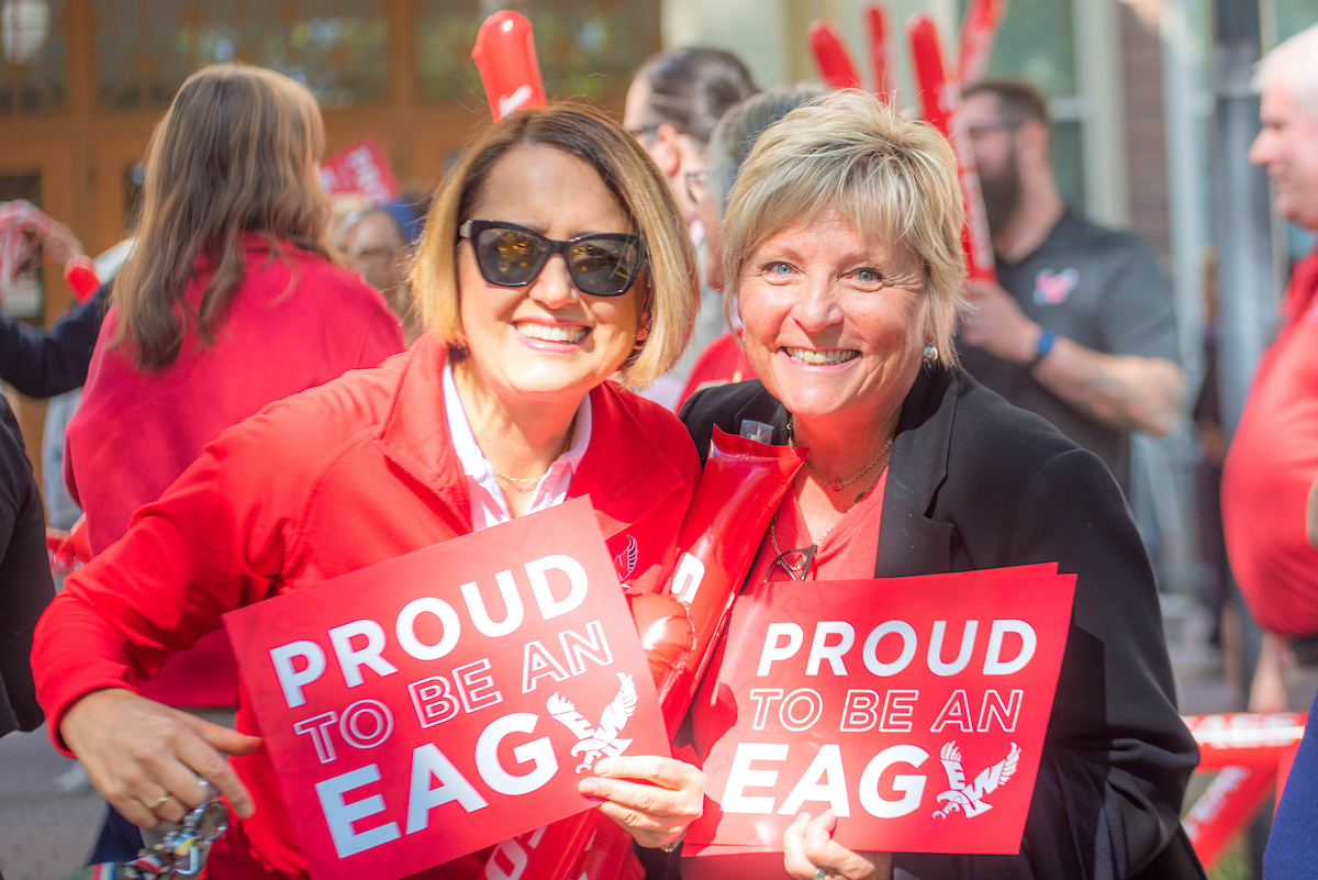 Two employees welcome new students.