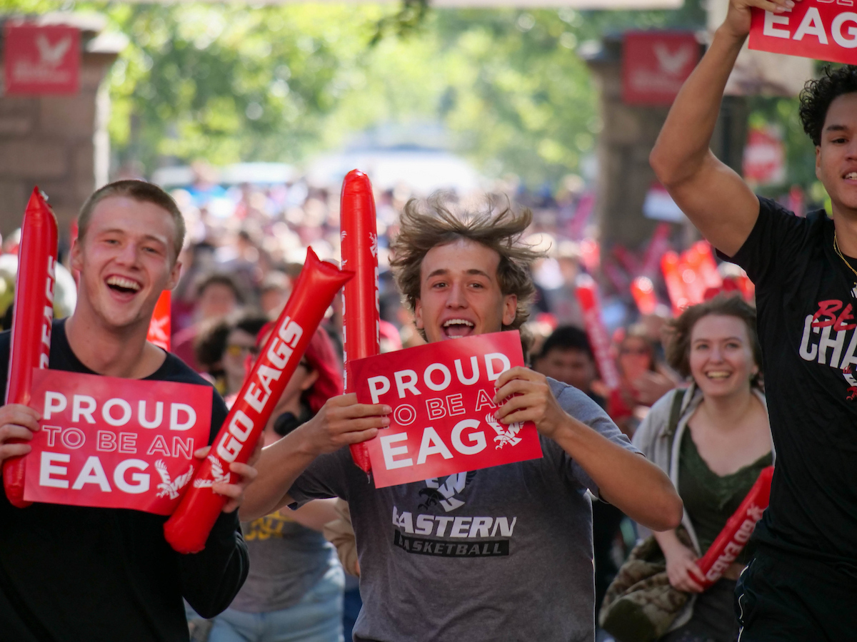 Two students holding up Proud to be an Eag signs.