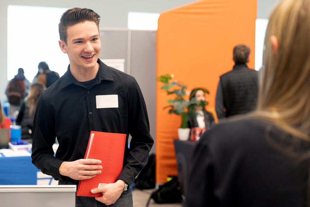 Student holding a folder and participating in a career event.