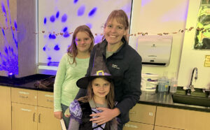 Mom with two children in costume.