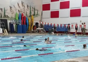 Aquatics pool with people swimming in lanes.