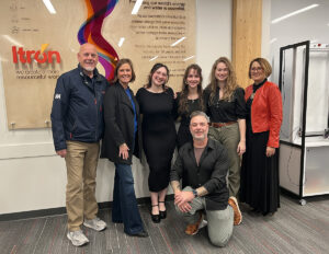 The Itron team and teh EWU team pose for a photo by the new sign.