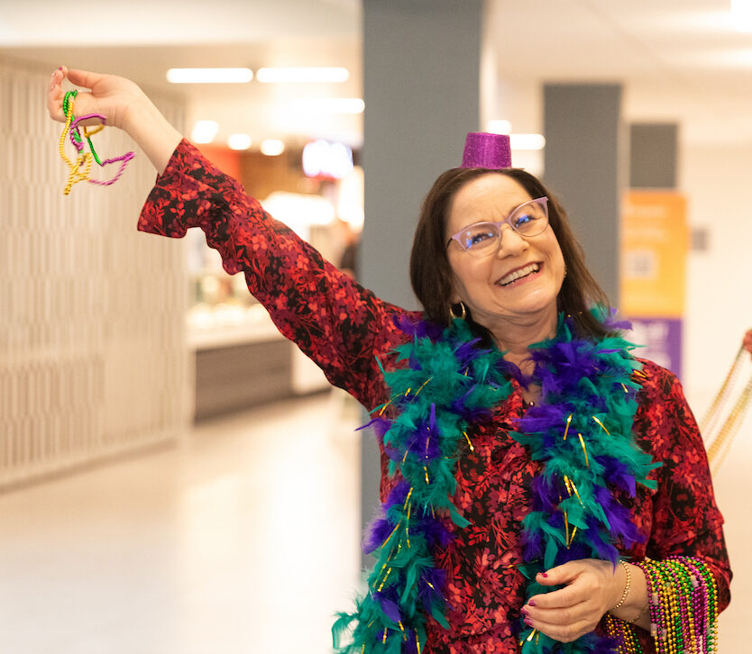 Lea Jarnagin wearing colorful attire at the Mardi Gras celebration.