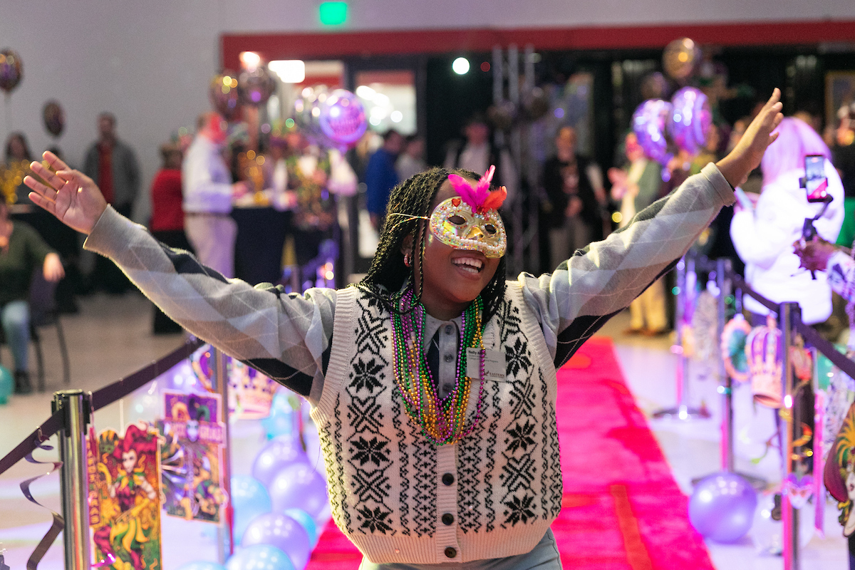 Employee decked out and waving on the pink carpet.