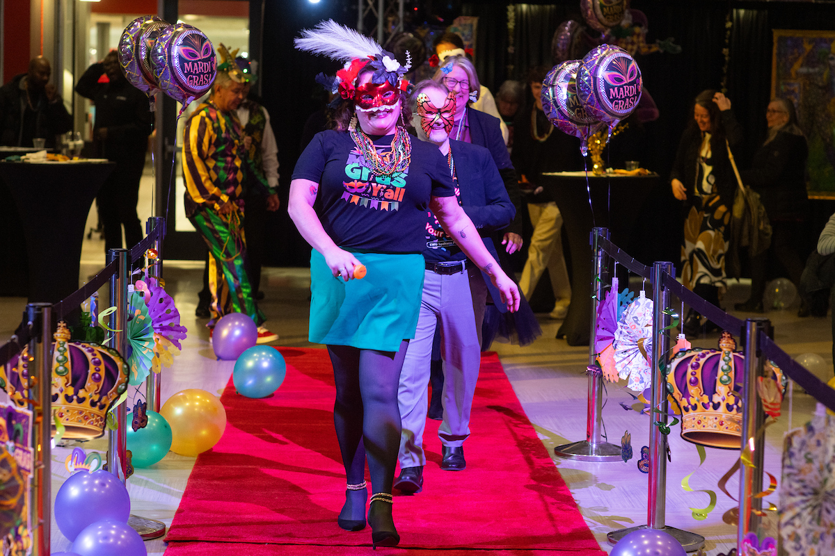 Several employees strolling on the runway carpet.