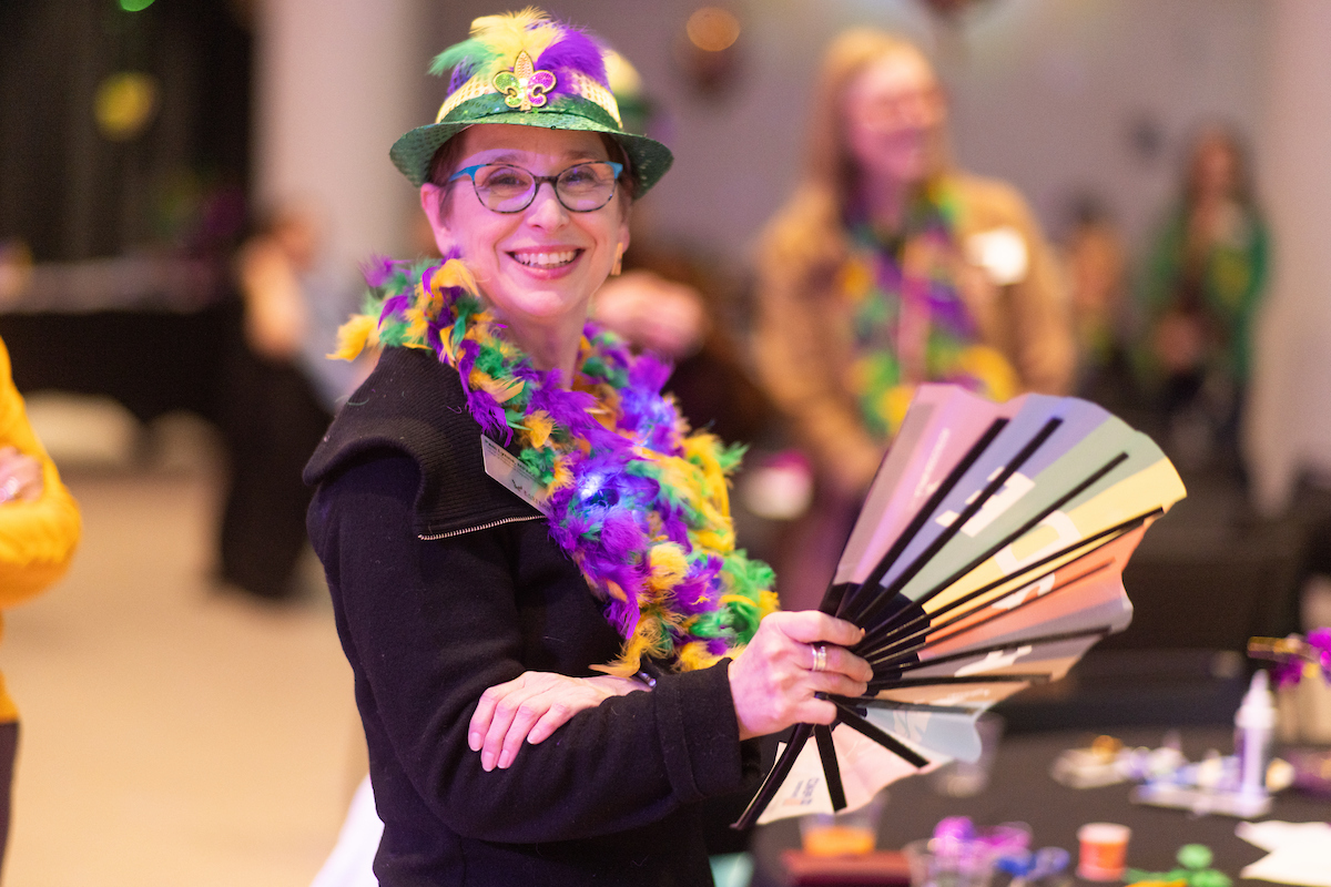 Employee decked out with a hat, scarf and fan.