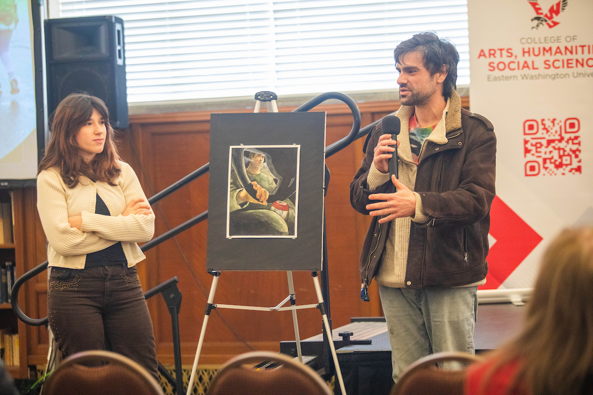 Student artist and her professor explaining a painting that illustrates a Jess Walter story.