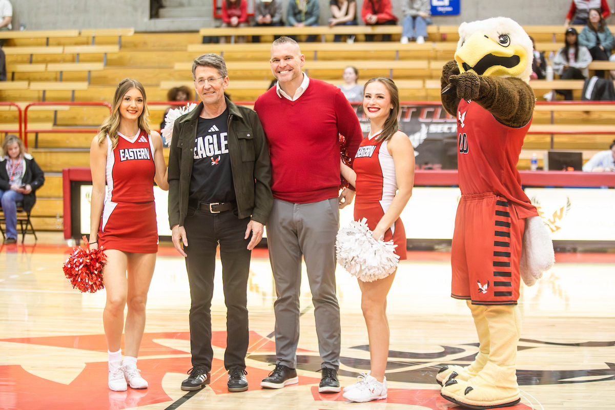 Jess Walter being honors at the EWU Men's Basketball game. He is standing with Tim Collins, Swoop and two cheer leaders.