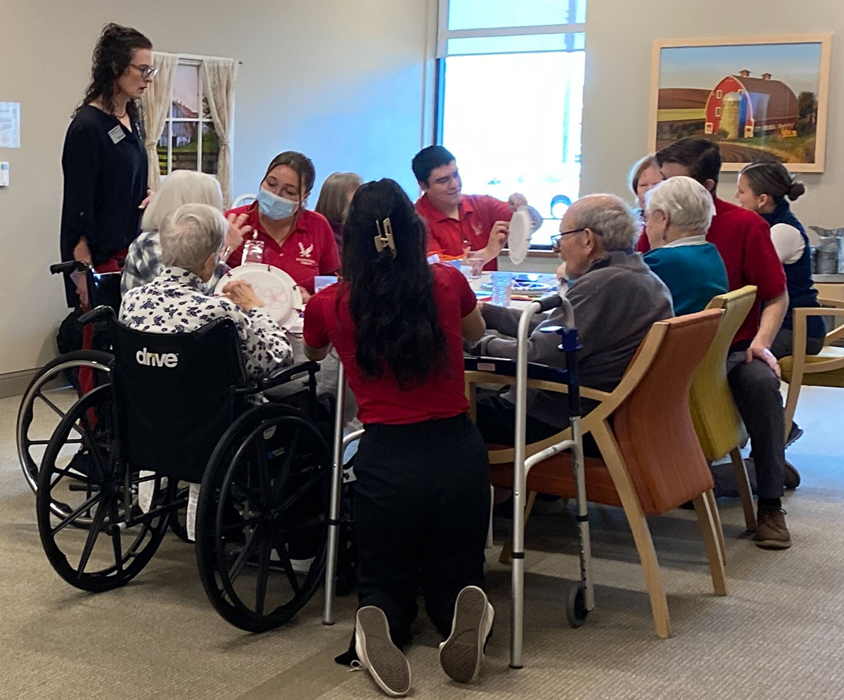 Eric Corona and other OTs working with a table of seniors at Riverview Retirement Community.