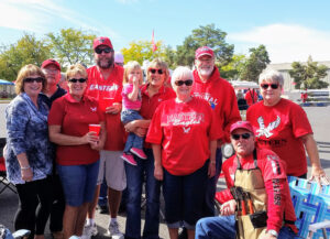 Zoë, a toddler, is with her grandparents and their friends, all dress in their Eagle gear, tailgating.