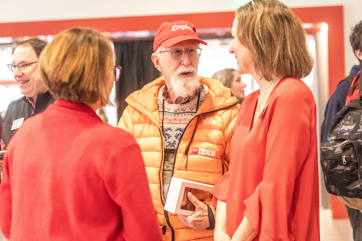 Bill Youngs talking with two members of the philanthropy staff