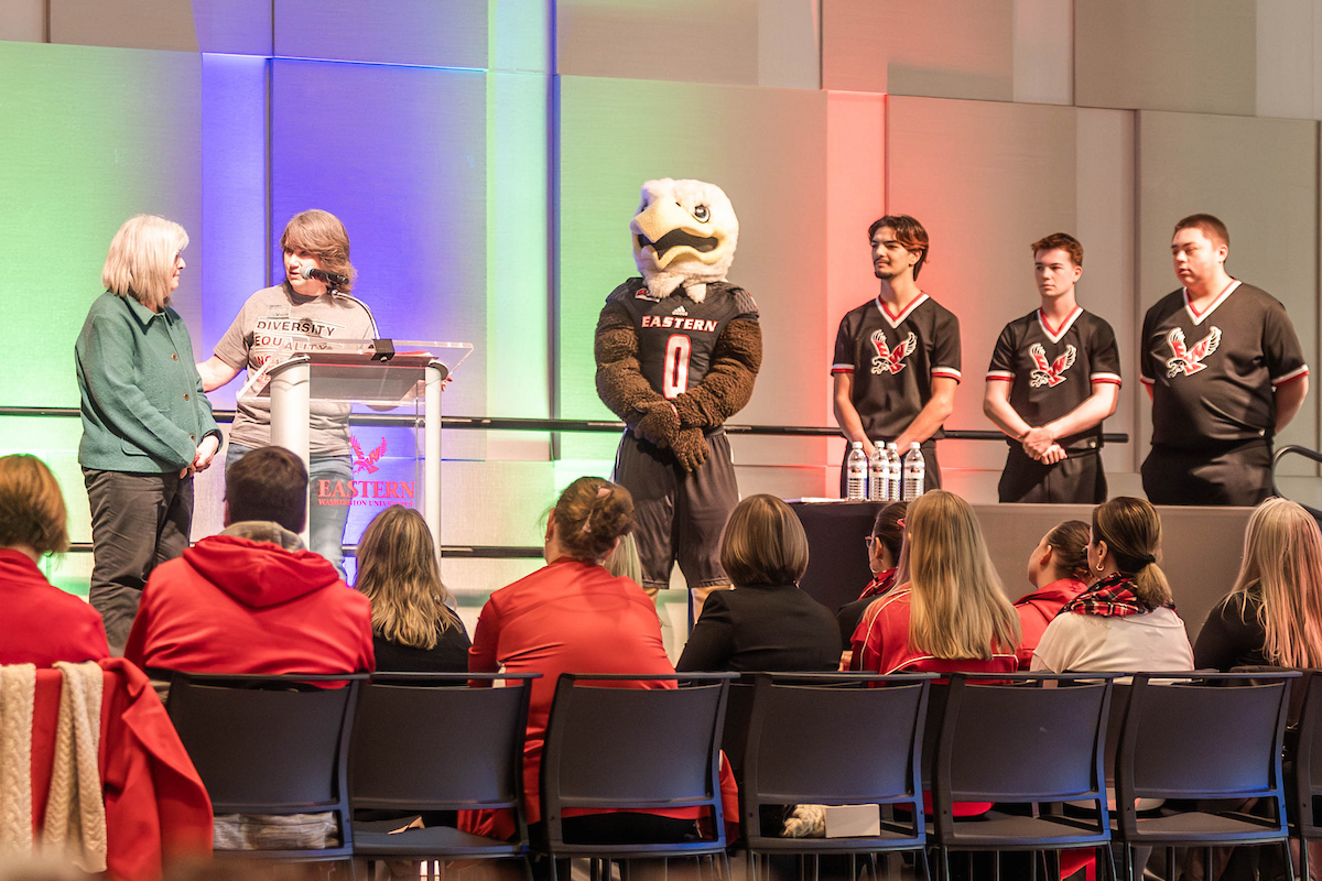 Bonnie Mager and Linda Safford on the stage with three cheer members and Swoop.