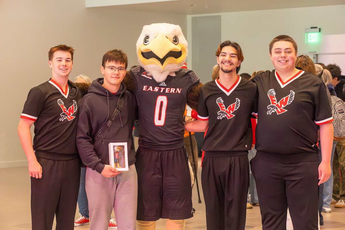 Four members of the cheer squad with Swoop.