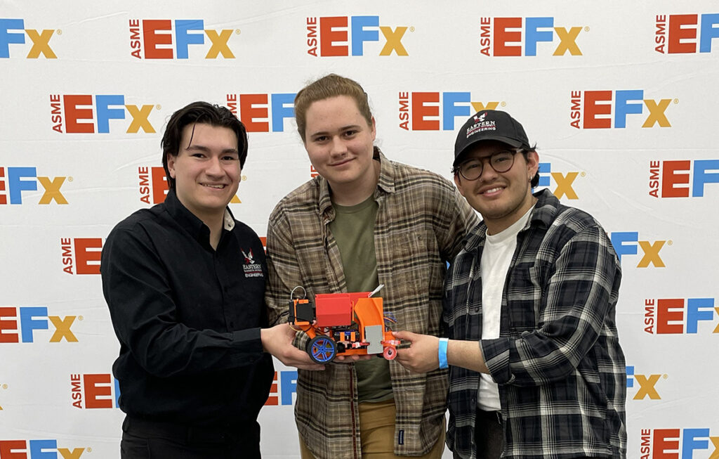The three engineering students with their robot.