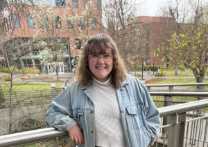 Emily on the steps of JFK with the ISC and some budding trees in the background.