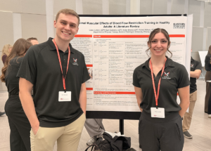 Two students standing with their poster presentation.