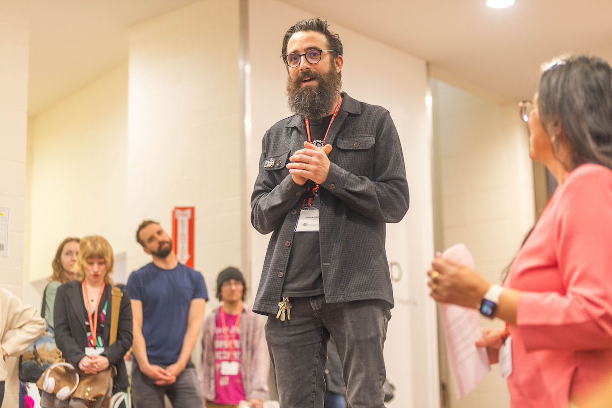 Joshua Hobson, faculty in art, speaking in front of attendees