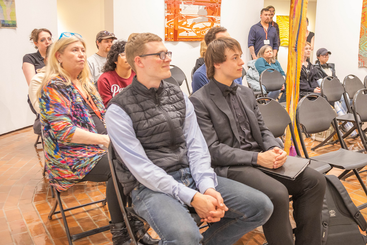 Students and faculty sitting and watching music performance