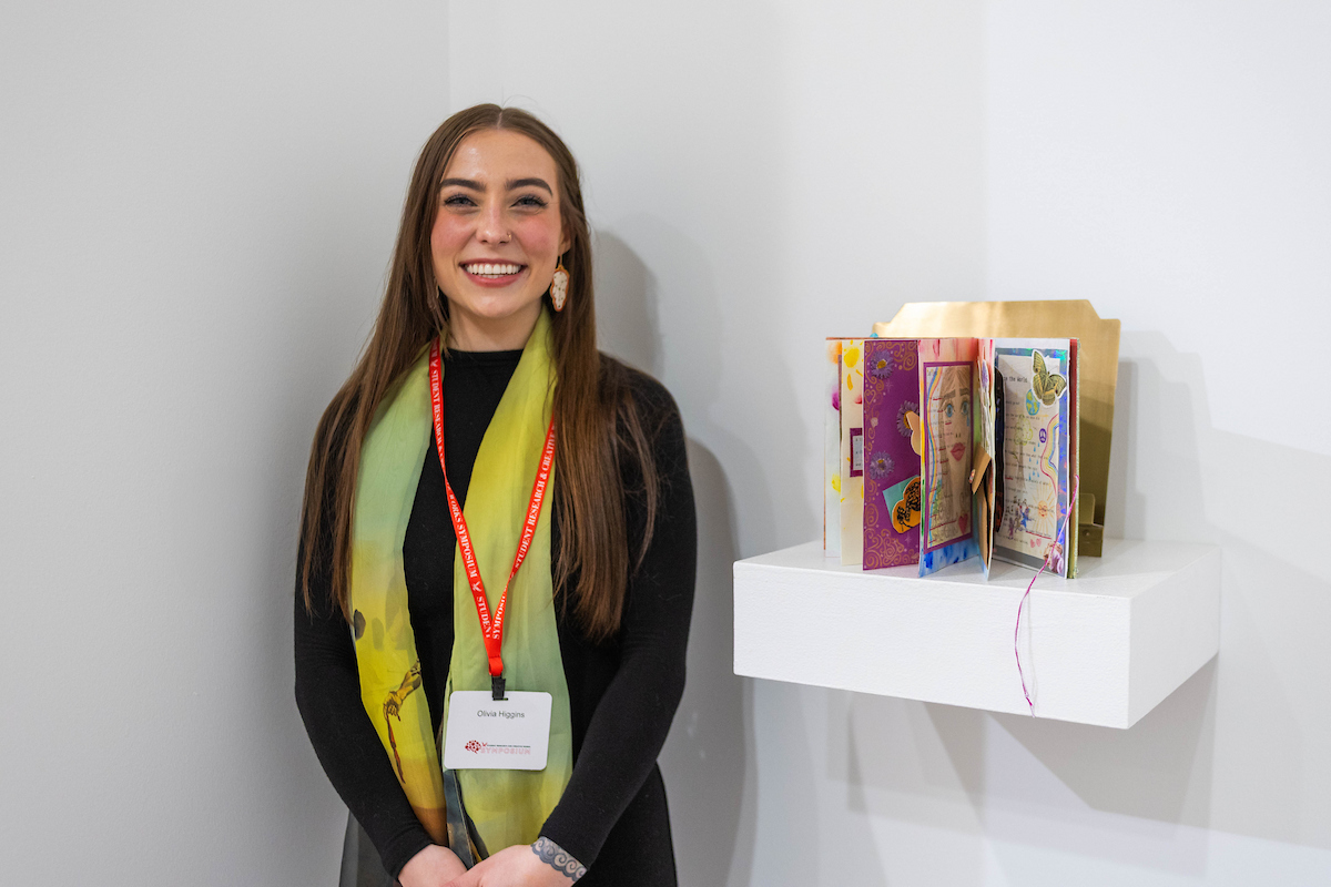 Student stands near book she created.