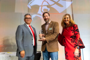 Photo of Chad Pritchard receiving an award. He is pictured with President McMahan and Cesar Portillo.