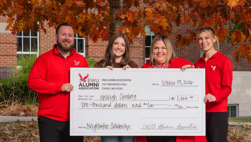 Haleigh Camberg holds a big check with the Alumni Association's Riley Baxter, Sarah Boldizar and Kelsey Hatch-Brecek.